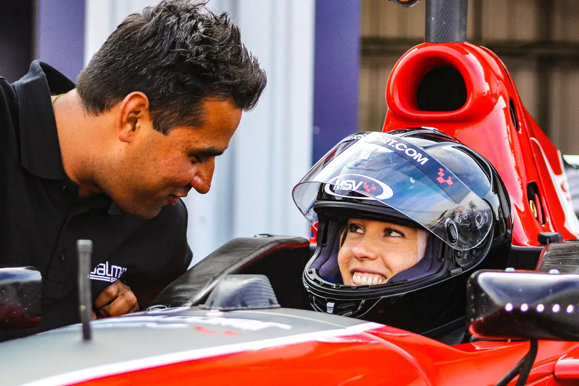 Instructor talking to smiling guest in the Formula 3000