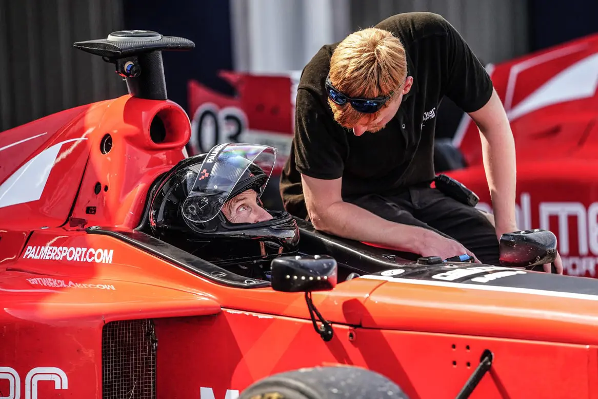 Instructor leaning over guest in Formula 3000