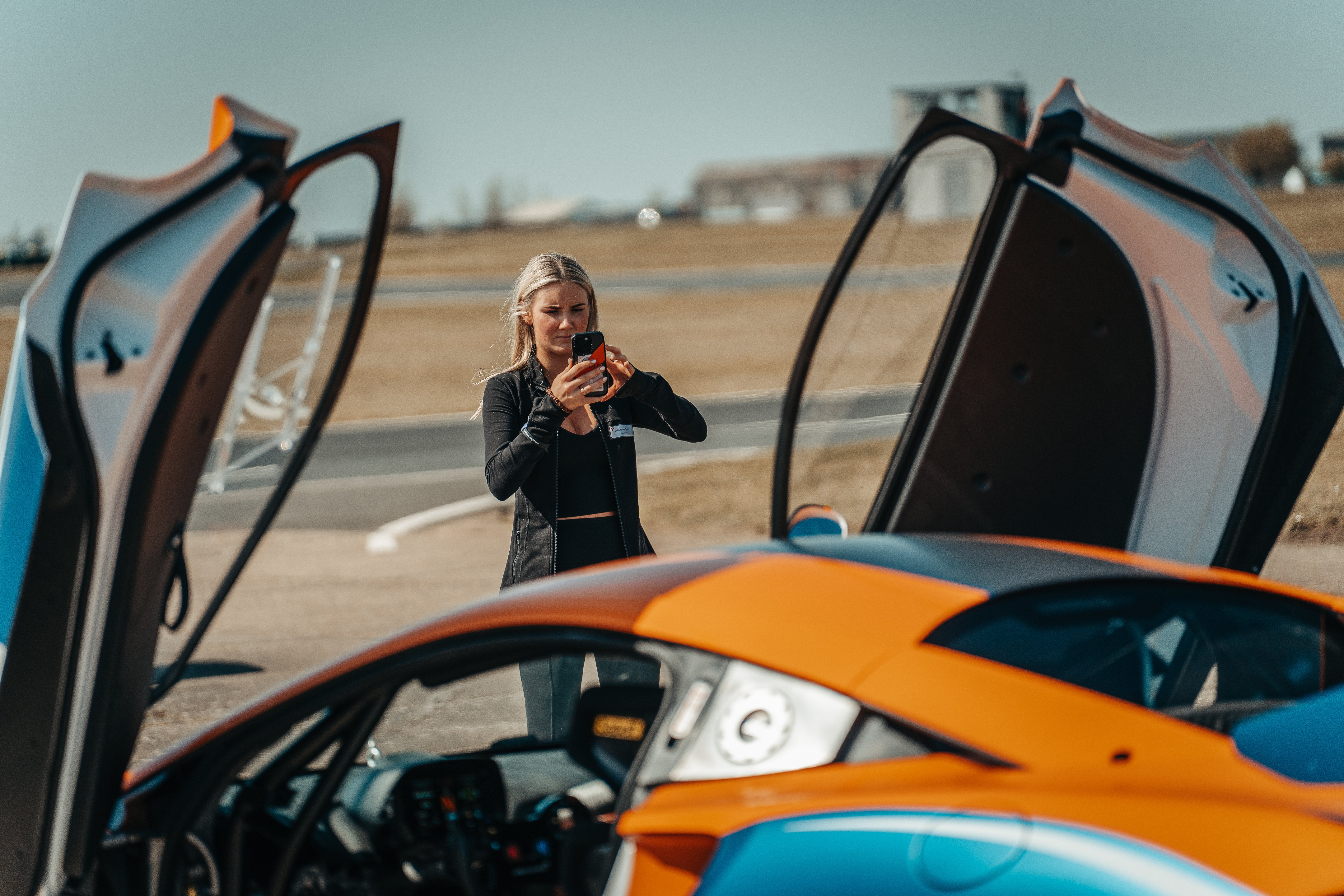 Lady taking photo of new McLaren 